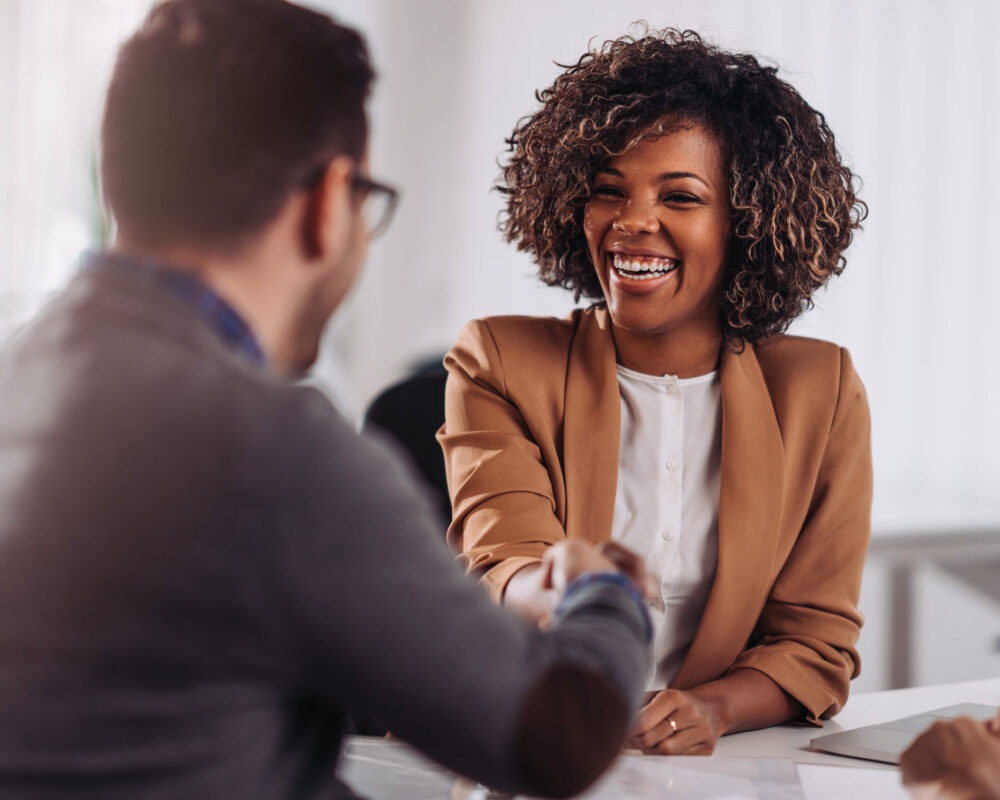 Happy businesswoman shaking hands with colleage after successful meeting